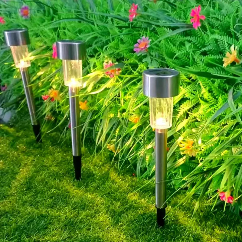 Solar garden lights on grass with flowers in the background